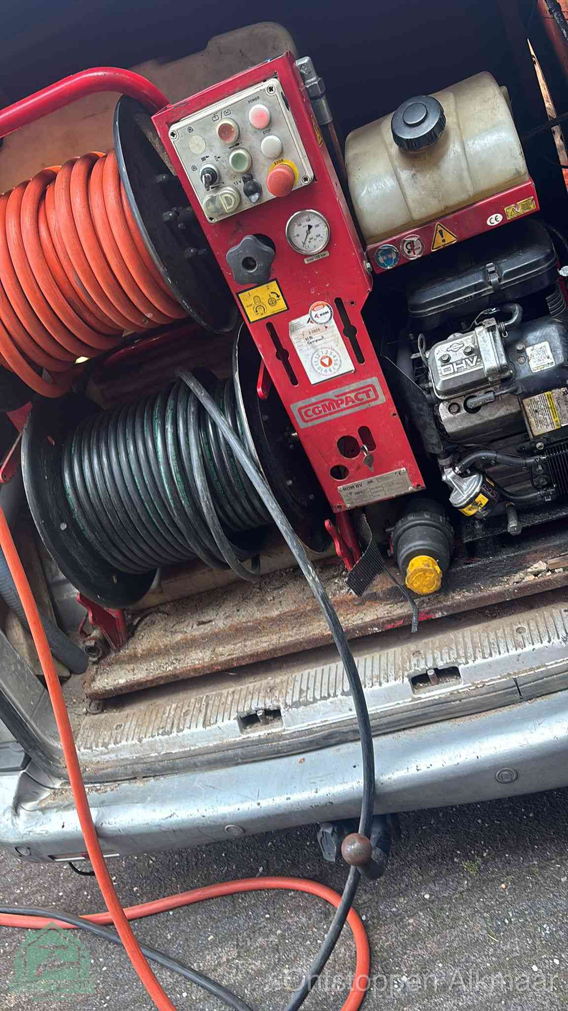 Een rood hogedruk-rioolreinigingstoestel in de laadbak van de bedrijfsbus, apparatuur voor een hardnekkige afvoerverstopping in Alkmaar