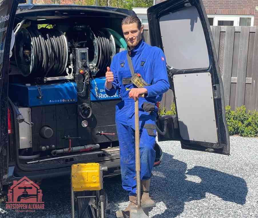 Een monteur bij de werkbus met grote hogedruk-slanghaspels, apparatuur voor hardnekkige afvoerverstoppingen in Alkmaar