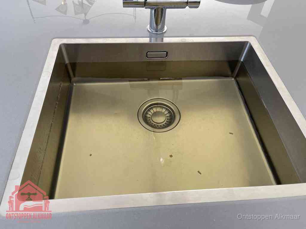 Stilstaand water in een rvs spoelbak dat niet wegloopt, een duidelijk signaal van een gootsteenverstopping in Alkmaar