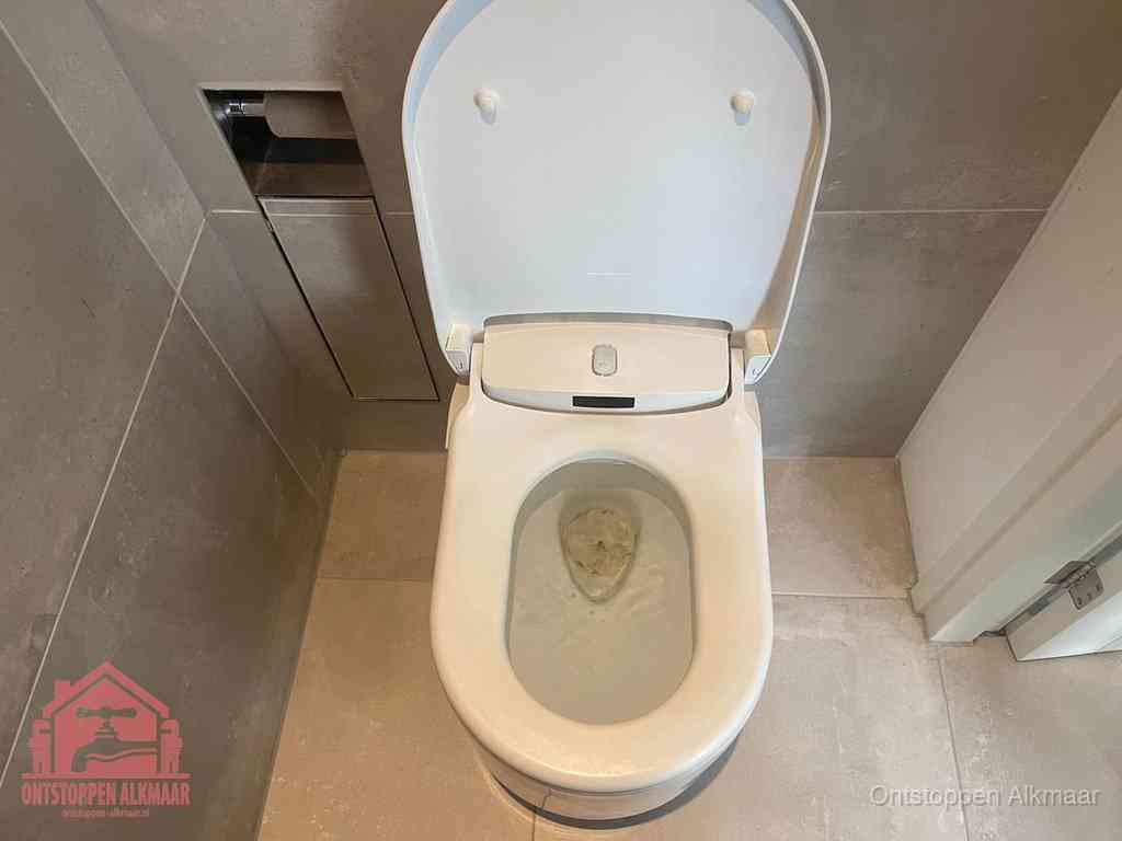 Een wit hangtoilet waarin een prop wc-papier op het water blijft drijven, een duidelijk signaal van een verstopte wc in Alkmaar
