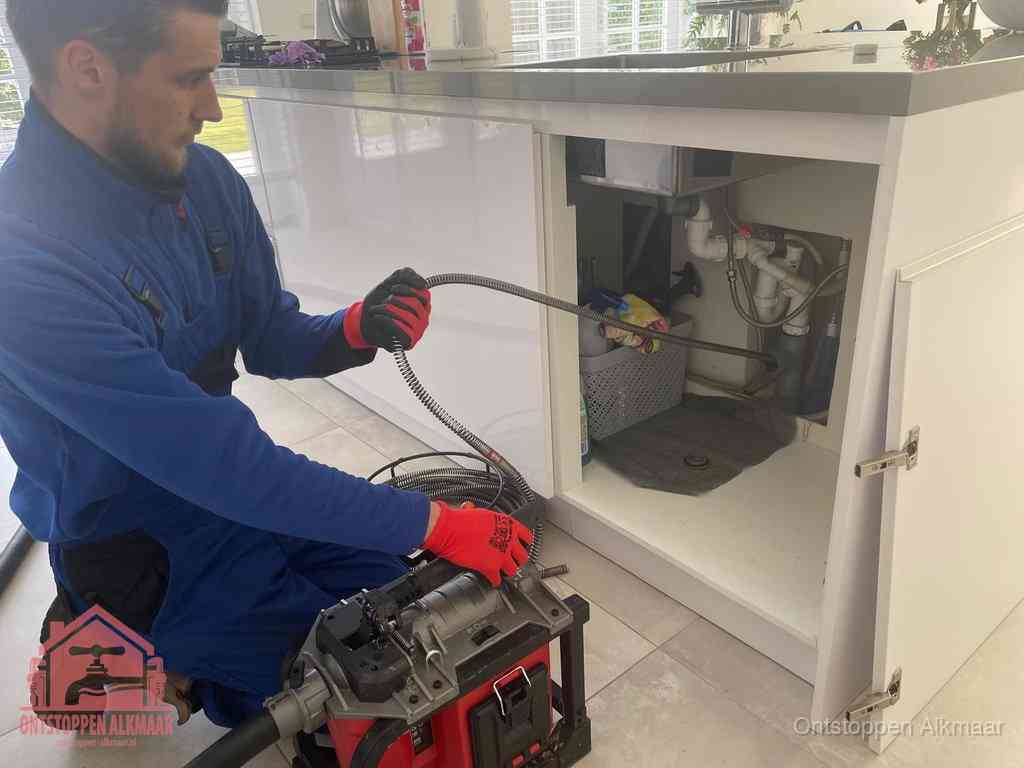 Een monteur reinigt de keukenafvoer grondig met een veermachine om terugkerende gootsteenverstoppingen te voorkomen in Alkmaar